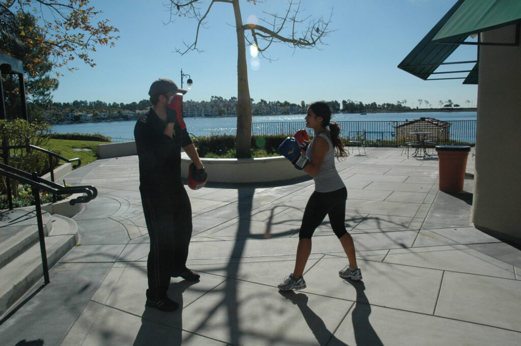 personal trainer in Mission viejo working outside with female sparring with boxing gloves