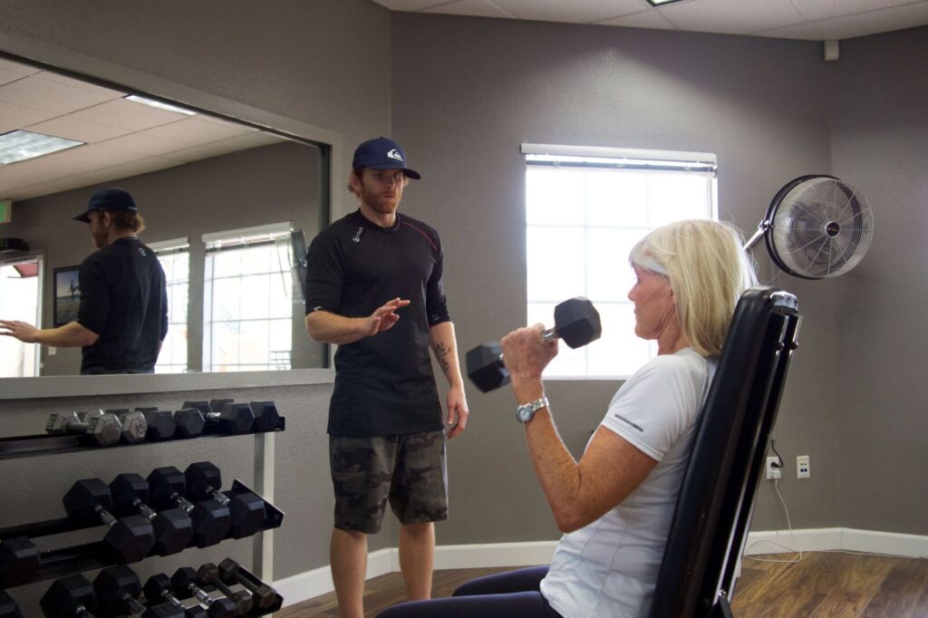 fitness coach in Mission Viejo with a black cap training woman in white shirt