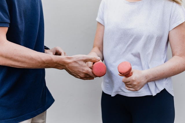 holding light weights for warm up with personal trainer