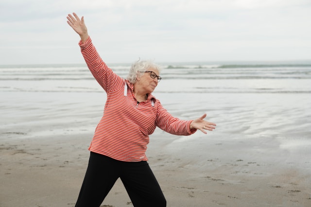 senior stretching on the beach 
